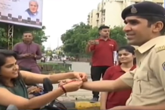 lady tieing rakhi to traffic police